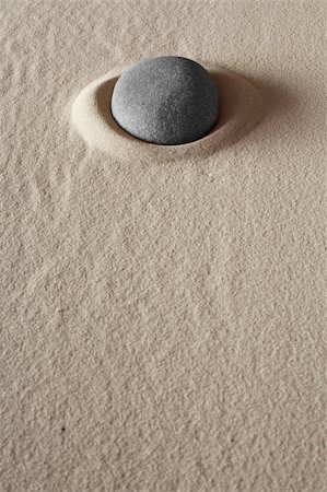 zen meditation stone relaxation or concentration point to focus and to meditate round grey rock in dry sand simplicity and purity spa background abstract concept Foto de stock - Super Valor sin royalties y Suscripción, Código: 400-06087188