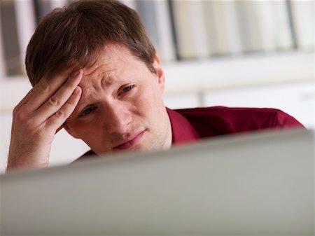 simsearch:400-05363701,k - overworked businessman working on laptop computer and having headache. Copy space Stock Photo - Budget Royalty-Free & Subscription, Code: 400-06087366
