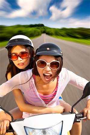 driving scooter women - two girls riding scooter on the road Stock Photo - Budget Royalty-Free & Subscription, Code: 400-06088320