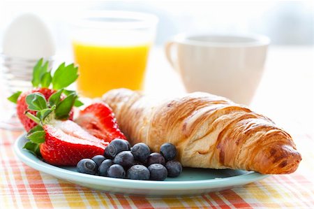 Croissant, fresh strawberries and blueberries, coffee, orange juice and an egg for healthy breakfast Stock Photo - Budget Royalty-Free & Subscription, Code: 400-06088354