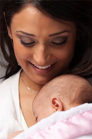 Young Attractive Ethnic Woman Holding Her Newborn Baby Under Dramatic Lighting. Stock Photo - Budget Royalty-Free & Subscription, Code: 400-06080064