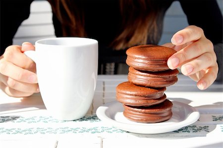 finger cookie - girl holding a cup of coffee and cake Foto de stock - Super Valor sin royalties y Suscripción, Código: 400-06083272