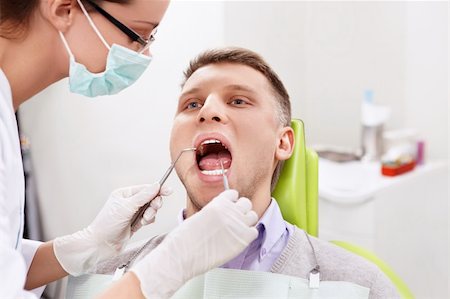 simsearch:400-04340942,k - The dentist treats teeth of the man in the dental clinic Stock Photo - Budget Royalty-Free & Subscription, Code: 400-06083419