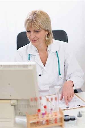 simsearch:400-07099889,k - Portrait of smiling middle age doctor woman working on computer Stock Photo - Budget Royalty-Free & Subscription, Code: 400-06094487