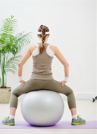 Slim woman sitting on fitness ball back to camera Stock Photo - Budget Royalty-Free & Subscription, Code: 400-06094540