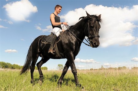 young man and his black stallion in  a field Foto de stock - Super Valor sin royalties y Suscripción, Código: 400-06096815