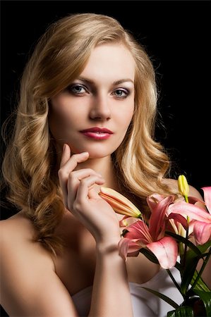 simsearch:400-06096871,k - fashion portrait of a young pretty blond girl with pink lily over black background looking in camera, she is slightly turned of three quarters at left and her right hand is near the chin Stock Photo - Budget Royalty-Free & Subscription, Code: 400-06096871