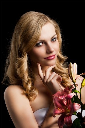 simsearch:400-06096871,k - fashion portrait of a young pretty blond girl with pink lily over black background looking in camera, she is turned of three quarters at left and her right hand is near the chin. Stock Photo - Budget Royalty-Free & Subscription, Code: 400-06096872