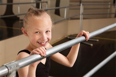 simsearch:400-06172148,k - Smiling cute ballet student holds railing in dance studio Stock Photo - Budget Royalty-Free & Subscription, Code: 400-06097051