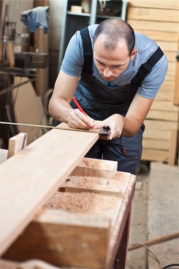 Man measuring a beech wood plank Stock Photo - Royalty-Free, Artist: Lamarinx, Image code: 400-06097099