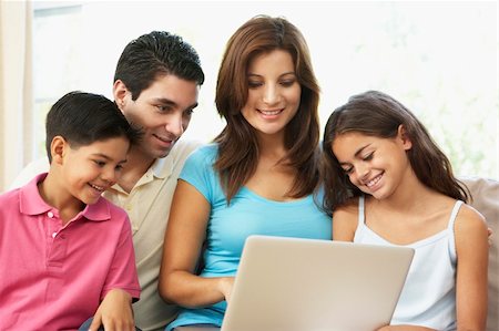 Family Sitting On Sofa At Home With Laptop Stock Photo - Budget Royalty-Free & Subscription, Code: 400-06097717