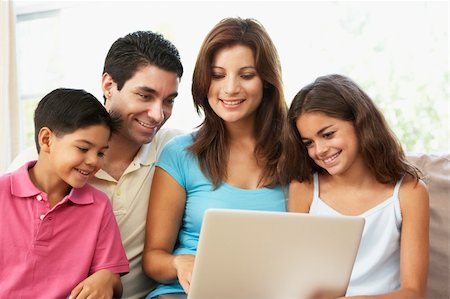 simsearch:400-04044108,k - Family Sitting On Sofa At Home With Laptop Stock Photo - Budget Royalty-Free & Subscription, Code: 400-06097719