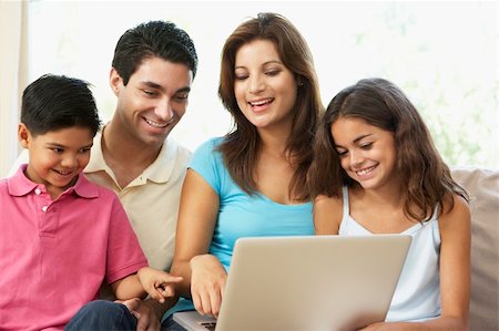 simsearch:400-04044122,k - Family Sitting On Sofa At Home With Laptop Stock Photo - Budget Royalty-Free & Subscription, Code: 400-06097720
