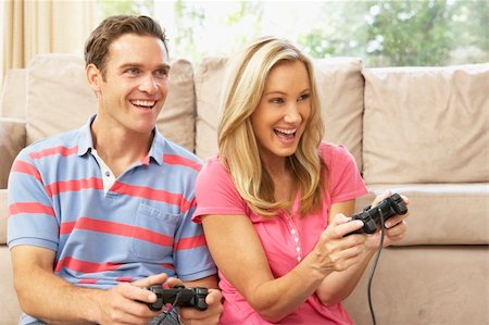 Young Couple Playing Computer Game On Sofa At Home Stock Photo - Budget Royalty-Free & Subscription, Code: 400-06098357