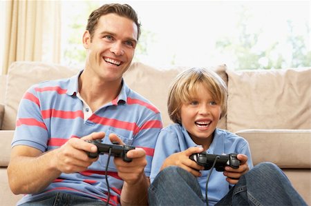 Father And Son Playing Computer Game On Sofa At Home Stock Photo - Budget Royalty-Free & Subscription, Code: 400-06098359