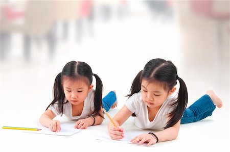Little Asian girls drawing, lying on floor Stock Photo - Budget Royalty-Free & Subscription, Code: 400-06098656