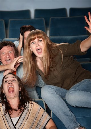 simsearch:400-06138368,k - Scared Caucasian teen jumps out of her seat in theater Stock Photo - Budget Royalty-Free & Subscription, Code: 400-06090247