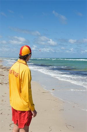 young man  life saver  watching the situation on the sea Stock Photo - Budget Royalty-Free & Subscription, Code: 400-06091586