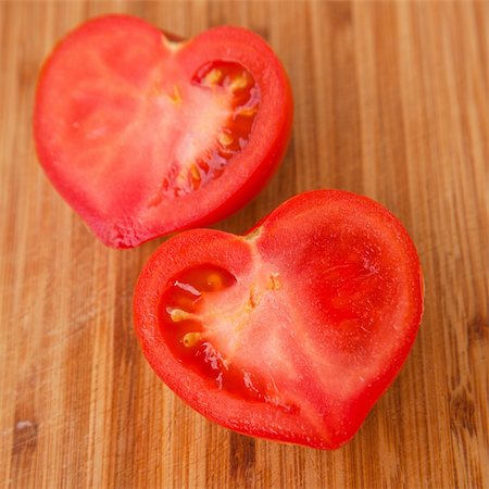 say it with tomatoes - heart-shaped tomato cut in half on a wooden chopping board Foto de stock - Super Valor sin royalties y Suscripción, Código: 400-06091851