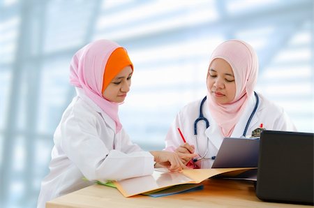 Two Muslim female doctor discussing patient report Stock Photo - Budget Royalty-Free & Subscription, Code: 400-06092785
