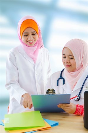 Two female Muslim doctor discussing on medical report Stock Photo - Budget Royalty-Free & Subscription, Code: 400-06092786