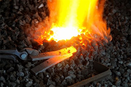 A pair of tongs gripping heated metal on glowing coal in forge Stock Photo - Budget Royalty-Free & Subscription, Code: 400-06093518