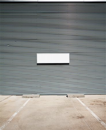 simsearch:400-06105442,k - Concrete parking floor and tin wall with blank info board. Foto de stock - Super Valor sin royalties y Suscripción, Código: 400-06105442