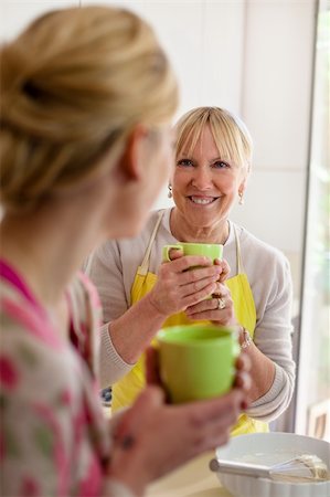 Happy women in home kitchen: mom and daughter talking and drinking a cup of tea Stock Photo - Budget Royalty-Free & Subscription, Code: 400-06105705