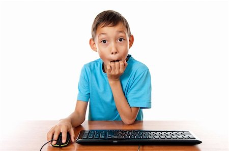 wondered boy sitting in front of computer with expression on his face isolated on white Stockbilder - Microstock & Abonnement, Bildnummer: 400-06106102