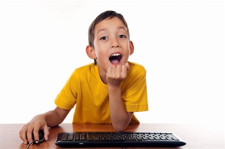 wondered boy sitting in front of computer with expression on his face isolated on white Stockbilder - Microstock & Abonnement, Bildnummer: 400-06106103