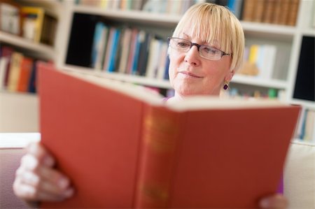 Portrait of happy retired caucasian woman with eyeglasses reading book at home Stock Photo - Budget Royalty-Free & Subscription, Code: 400-06106334