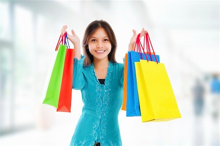 simsearch:400-06092781,k - Excited mixed race Asian female holding shopping bag in shopping mall Photographie de stock - Aubaine LD & Abonnement, Code: 400-06106597