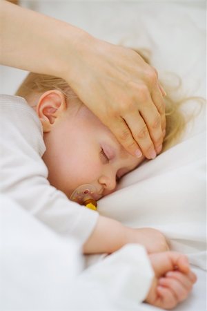 Closeup on mother checking temperature of forehead of baby Stock Photo - Budget Royalty-Free & Subscription, Code: 400-06106780