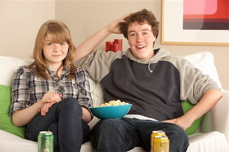 Teenage Couple Sitting On Sofa Watching TV Stock Photo - Budget Royalty-Free & Subscription, Code: 400-06107392
