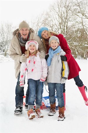 simsearch:400-05686748,k - Family Pulling Sledge Through Snowy Landscape Fotografie stock - Microstock e Abbonamento, Codice: 400-06107495