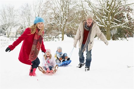 simsearch:400-05686748,k - Family Pulling Sledge Through Snowy Landscape Fotografie stock - Microstock e Abbonamento, Codice: 400-06107496