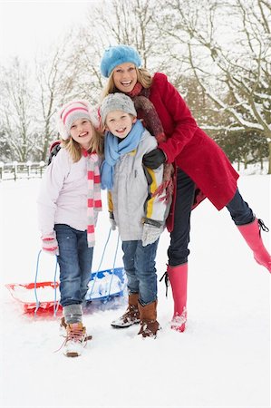 simsearch:400-05686748,k - Mother Pulling Sledge Through Snowy Landscape Fotografie stock - Microstock e Abbonamento, Codice: 400-06107493