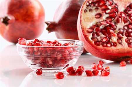 simsearch:400-05265200,k - Ripe pomegranates and glass bowl of seeds on white background Photographie de stock - Aubaine LD & Abonnement, Code: 400-06109012