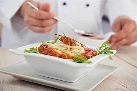 Male chef in restaurant kitchen is garnishing and preparing pasta dish Stock Photo - Budget Royalty-Free & Subscription, Code: 400-06100028