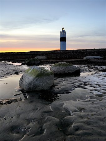 lighthouse late at night after sunset with rocks in the foreground Foto de stock - Super Valor sin royalties y Suscripción, Código: 400-06101272