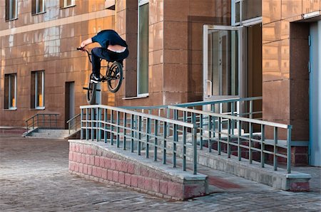 Biker doing high rail hop trick on bmx, back view Stock Photo - Budget Royalty-Free & Subscription, Code: 400-06101519