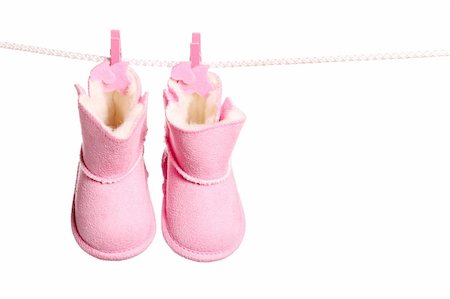Pair of pink winter boots hanging on the clothesline. Image isolated on white background Photographie de stock - Aubaine LD & Abonnement, Code: 400-06102841