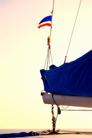 sailboat pulley - The Thai flag waves in the wind above the boom of a sailboat Stock Photo - Budget Royalty-Free & Subscription, Code: 400-06103671