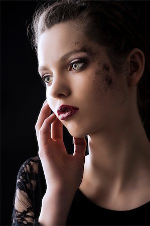 simsearch:400-06103705,k - close up portrait of very beautiful young lady actrees over a dark background with dirty make up and fashion light, she is turned of three quarters at right, she looks in front of her and her right hand is near the face Foto de stock - Super Valor sin royalties y Suscripción, Código: 400-06103704