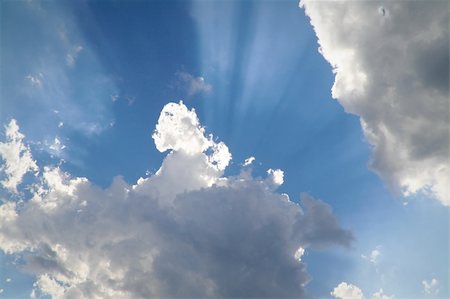 A photograph of rays of sunshine appearing from behind dark clouds. Fotografie stock - Microstock e Abbonamento, Codice: 400-06103835