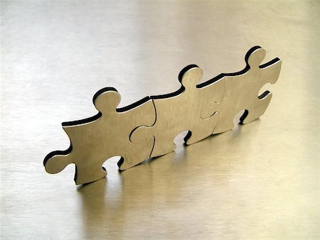 Three steel jigsaw against a metallic background Stock Photo - Budget Royalty-Free & Subscription, Code: 400-06126711