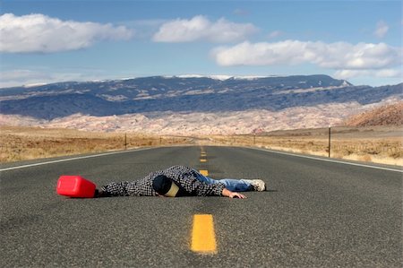 exhausted man on the road - man out of gas in the middle of nowhere, collapsed in the middle of the road while looking for a gas station Stock Photo - Budget Royalty-Free & Subscription, Code: 400-06126758