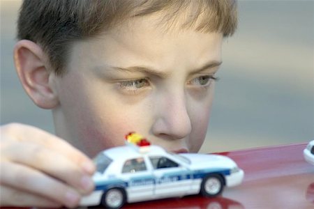 police and children - Boy playing with toy police cars Stock Photo - Budget Royalty-Free & Subscription, Code: 400-06128193