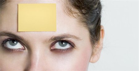 simsearch:400-03949678,k - girl looking up to a yellow post it sticked on her forehead. You can write whatever you want over it... Foto de stock - Super Valor sin royalties y Suscripción, Código: 400-06128870