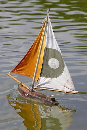 simsearch:400-08774807,k - Wooden sailing boat in jardin des tuileries paris france, Children can hire a small wooden toy sailing boat and using a stick push it around the pond Fotografie stock - Microstock e Abbonamento, Codice: 400-06129533